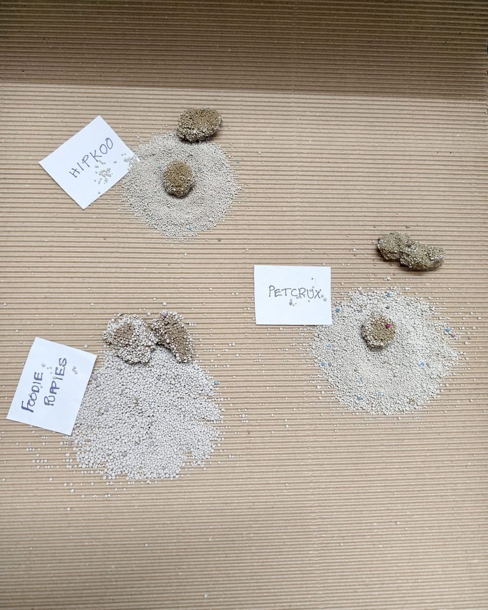 Three labelled piles of litter on cardboard with their clumps lifted out beside them